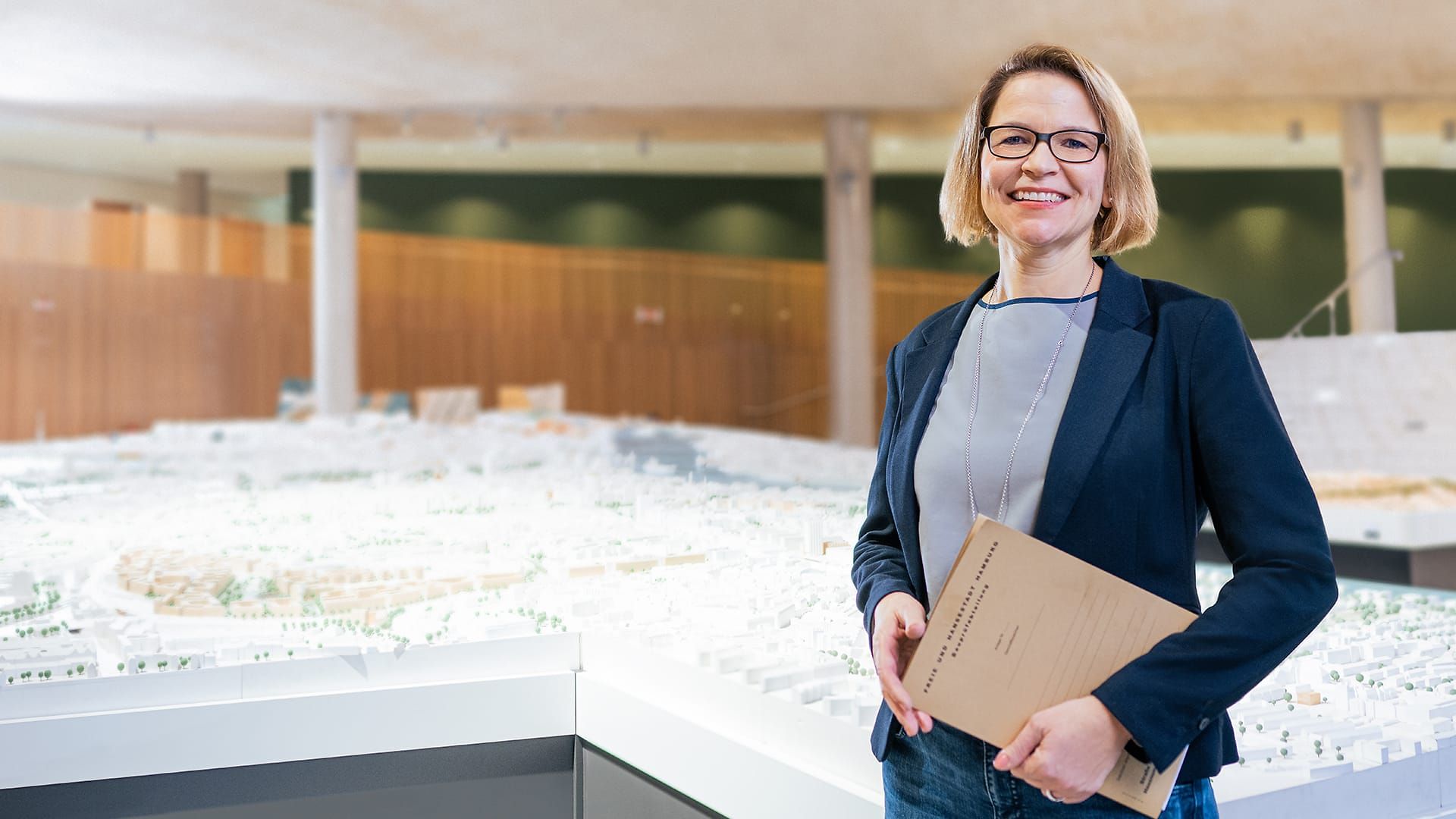 Eine Architektin steht vor dem Hamburger Stadtmodel.
